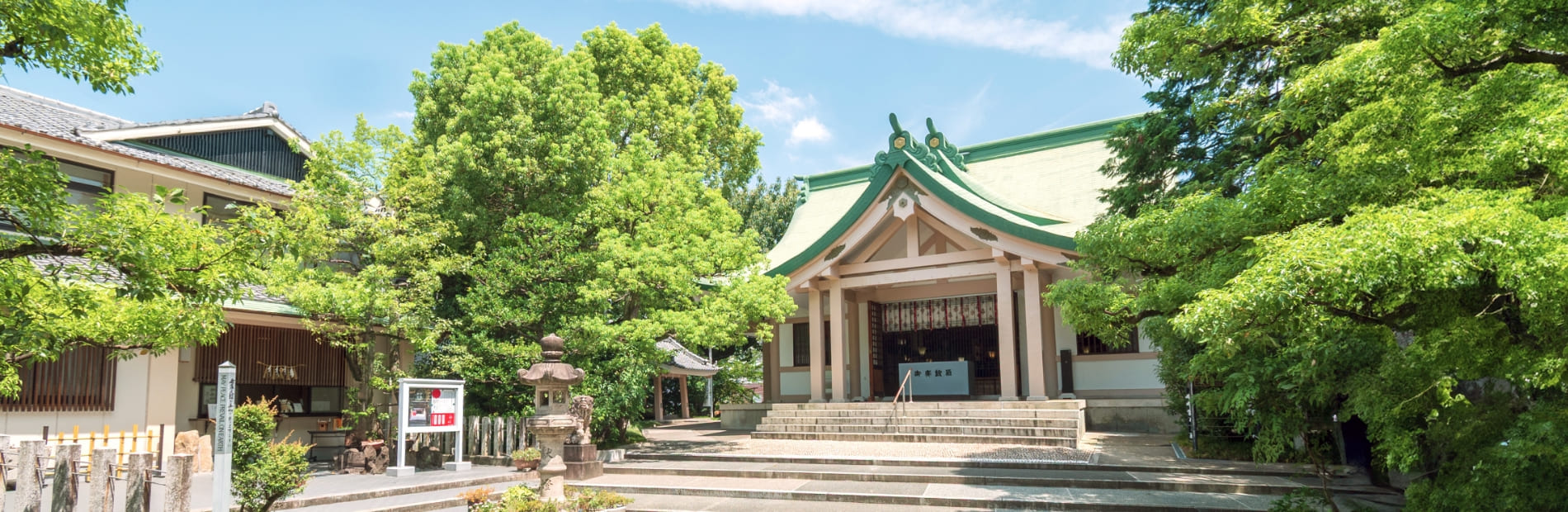 新栄白山神社 拝殿の外観の写真、緑の屋根と木々に囲まれている